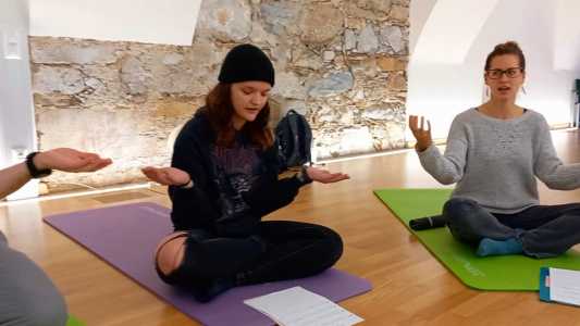 Studierende hockend bei einer Lichtermeditation