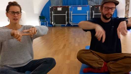 Studierende hockend bei einer Lichtermeditation