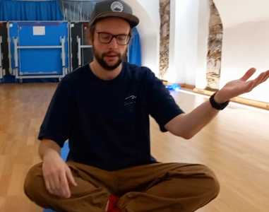 Studierender hockend bei einer Lichtermeditation