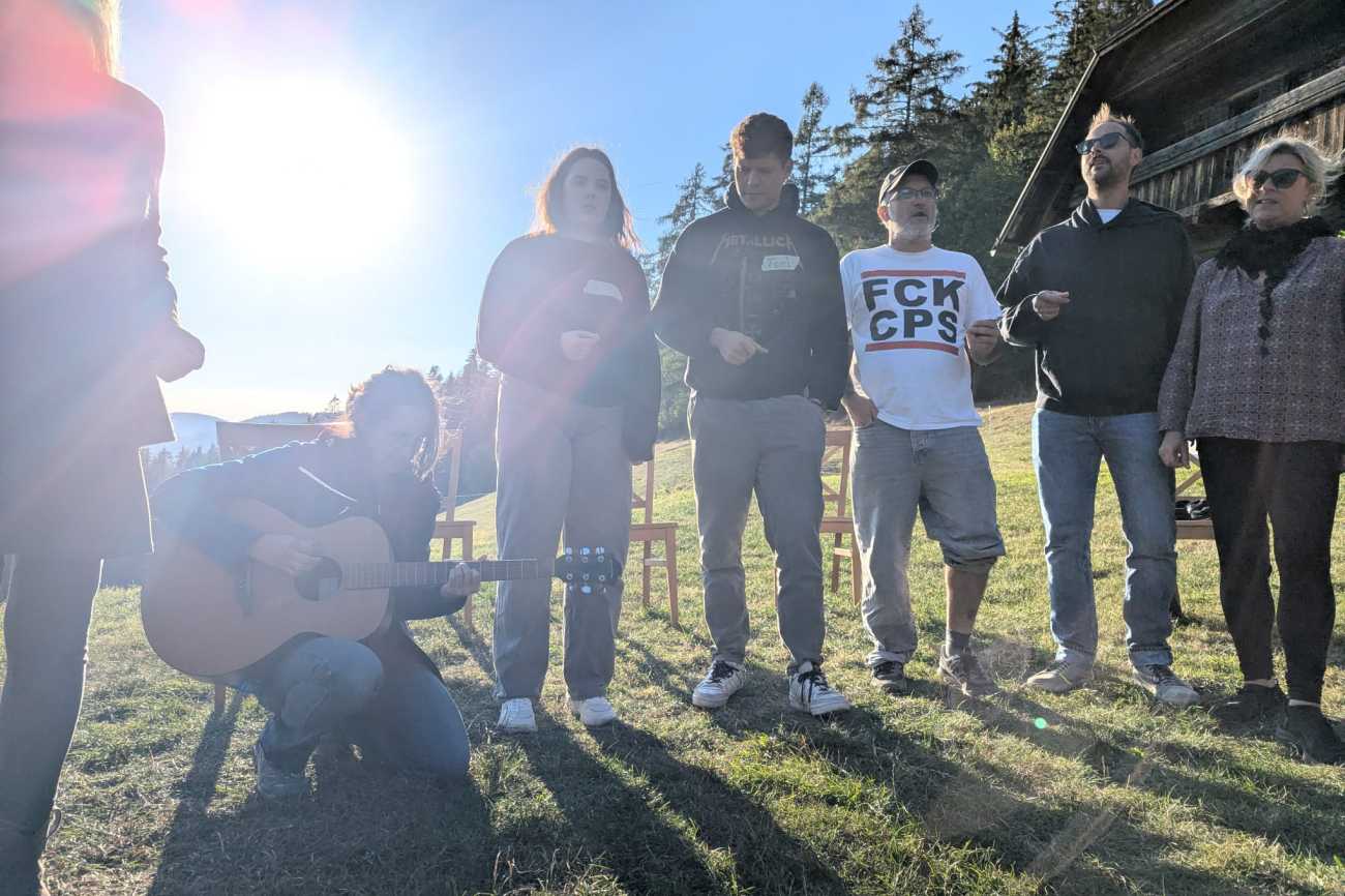 Lehrende mit Studierenden und Gitarre