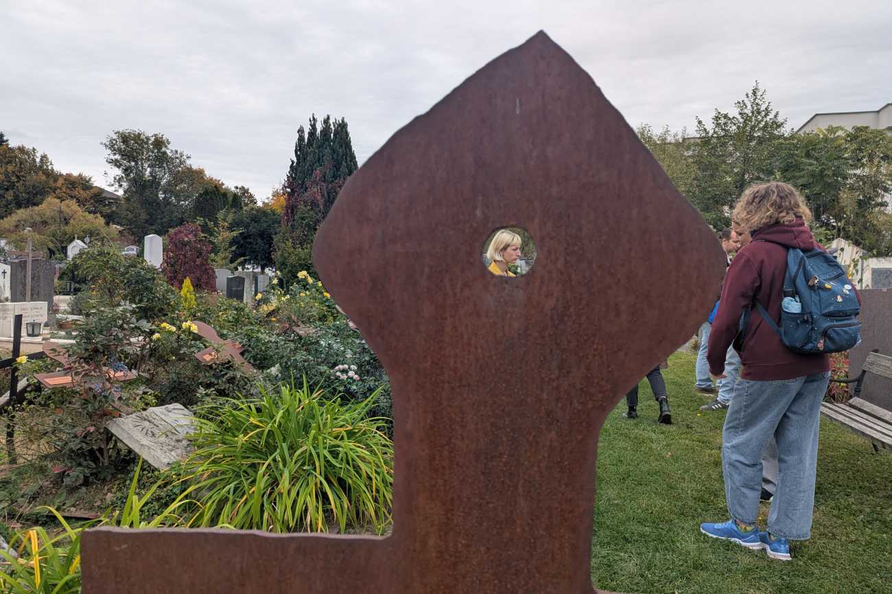 Vortragende hinter Blechkreuz